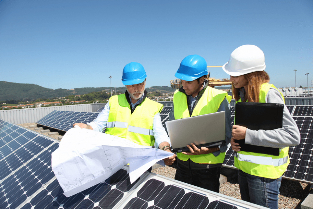 Grupo de ingenieros reunido sobre techo panel solar